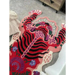 A vibrant Chinoiserie pink Tibetan tiger tufted wool rug displayed in a living room setting. This unique area rug features an abstract tiger design in bold colors, perfect for adding a striking focal point to large living room spaces. Ideal for those seeking eye-catching living room area rugs with a touch of cultural flair.