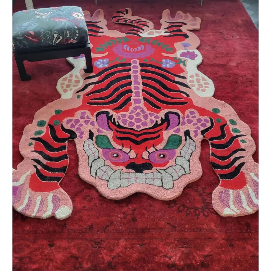 This vibrant Chinoiserie Pink Tibetan Tiger Tufted Wool Rug adds a bold statement to any living room. The area rug showcases a striking abstract tiger design in vivid pink, red, and black shades, perfect for those seeking unique living room area rugs. Crafted from high-quality wool, it offers both durability and style, making it an ideal choice for large living room rugs.