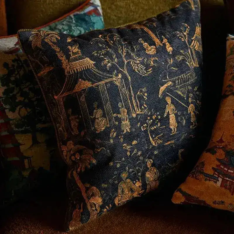 Chinoiserie throw pillow cover featuring intricate designs of figures and nature in gold and navy blue tones, perfect for adding a decorative touch to any living space.
