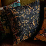 Chinoiserie throw pillow cover featuring intricate designs of figures and nature in gold and navy blue tones, perfect for adding a decorative touch to any living space.