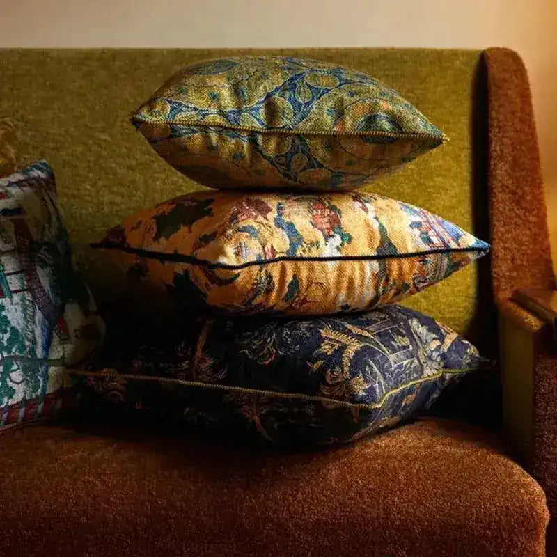 Chinoiserie throw pillows stacked on a sofa, featuring intricate patterns and vibrant colors, adding a touch of elegance to home decor.