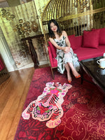 Chinoiserie Tibetan Tiger Hand Tufted Wool Rug in pink displayed in a stylish living room setting. The area rug features an abstract tiger design, ideal for large living room rugs or dining room decor. The vibrant wool rug adds a bold statement to any space.
