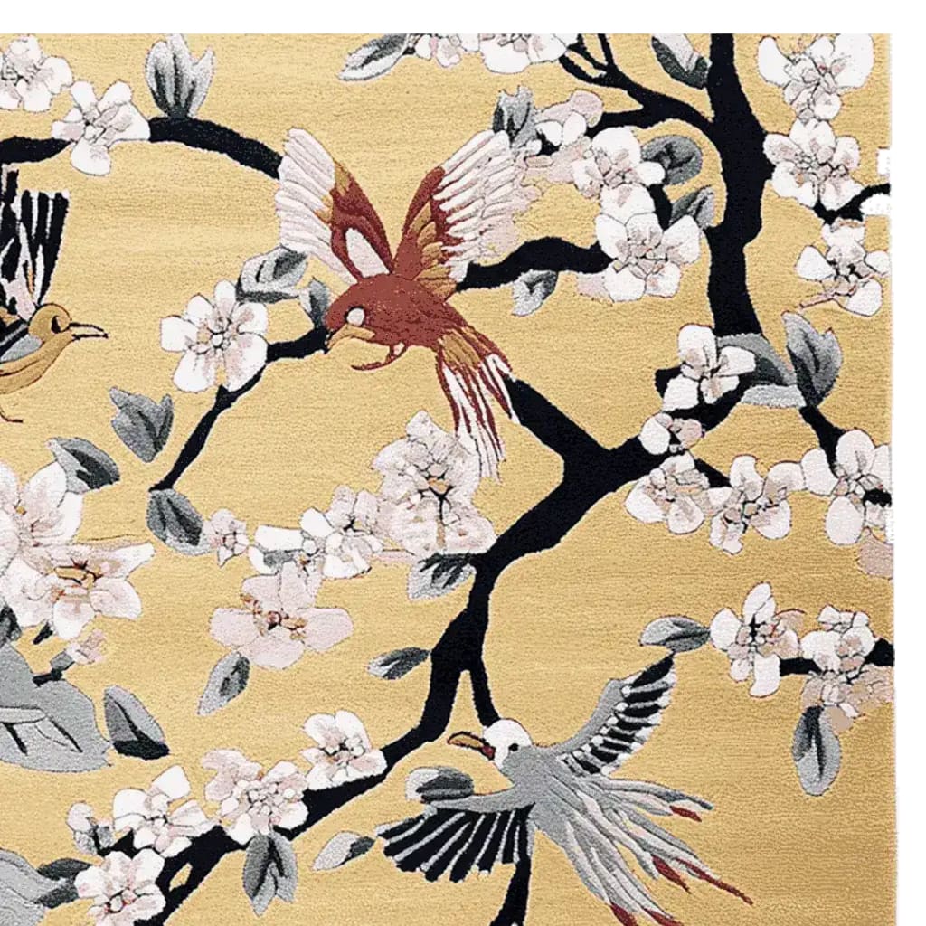 This image showcases the Chirping Petal Dance Hand Tufted Rug, a stunning area rug perfect for large living rooms. Made from high-quality wool, the rug features an intricate design of birds and cherry blossoms on a soft, golden background, adding a touch of elegance and nature-inspired beauty to any space.