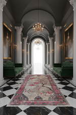Luxurious hallway with green velvet chairs, a floral rug, and classical architecture.