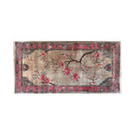 Top view of the Chorus of Blossoms Knotted Wool Area Rug featuring a beautiful floral design with vibrant pink blossoms and intricate branches on a soft beige background, bordered by an ornate pink and dark blue pattern.