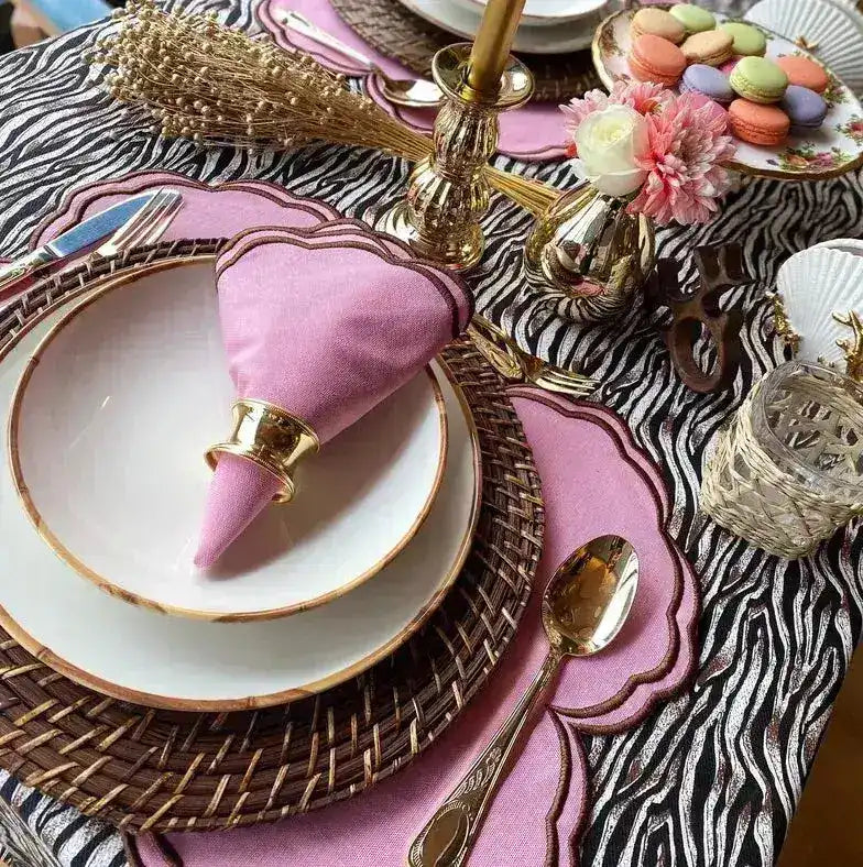 Cinnamon Swirl placemat pink with brown wave edge on metallic zebra cloth, gold-rim china and pink napkin