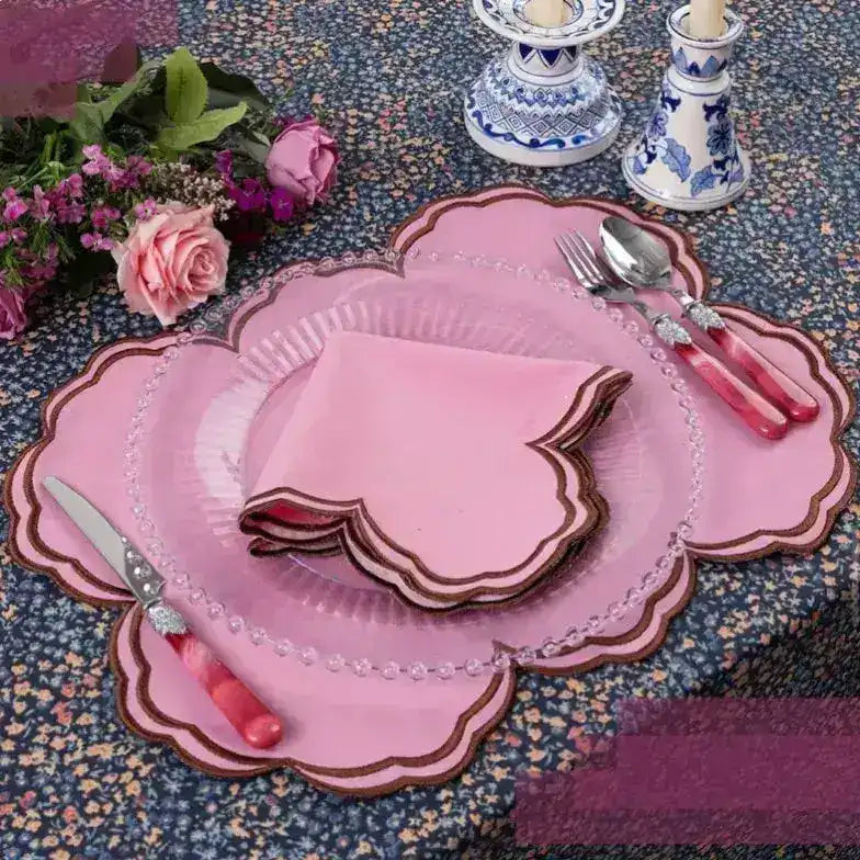 Cinnamon Swirl placemat in pink with brown scalloped edge, styled with pink roses and matching napkin