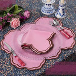 Cinnamon Swirl placemat in pink with brown scalloped edge, styled with pink roses and matching napkin