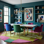 Modern dining room with colorful chairs and a geometric rug.