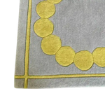 Close-up view of the Circle of Suns Square Hand Tufted Wool Rug in gray, showcasing its contemporary design with a pattern of yellow circles. This square area rug is perfect for adding a modern touch to any bedroom setting.