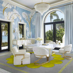 A stylish contemporary area rug in a gray and yellow pattern enhances the elegance of a sophisticated bedroom setting. This square wool rug complements the modern decor, serving as a perfect square area rug for bedroom spaces. Surrounded by chic furniture and a scenic view, the rug adds warmth and style to the room.