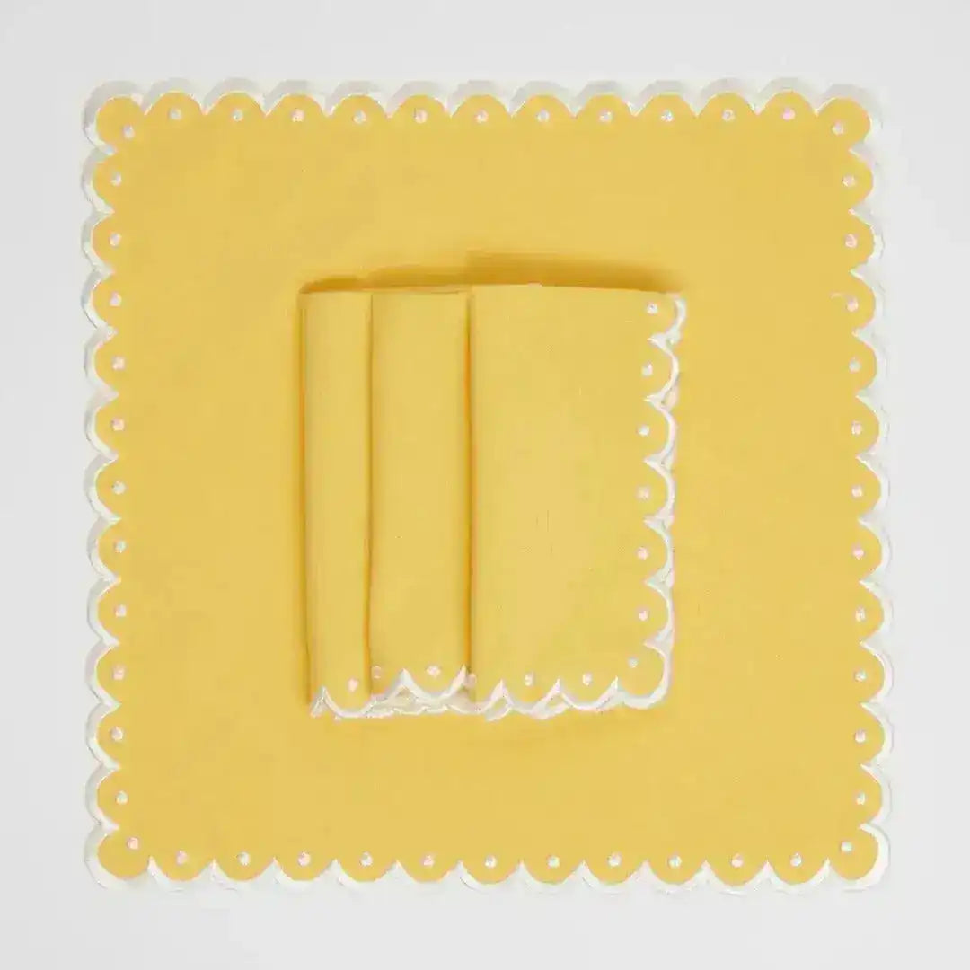 Citrus Glow placemat square flat lay, yellow with white scalloped eyelet border and folded yellow napkin
