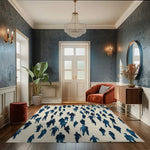 This elegant area rug, titled 'Cityscape Crowd Hand Tufted Rug', graces a sophisticated living room setting. Its abstract design features silhouettes of people in shades of blue, perfect for adding a modern touch to formal dining room rugs or a dining table rug. The wool rug enhances the room's ambiance, complementing the plush armchair, sleek sideboard, and the chandelier above.