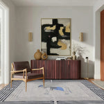 A stylish office setting featuring the Classic Horse Silver Maze hand-tufted area rug. The wool rug is elegantly placed in a room with a modern armchair, a sleek sideboard, and contemporary artwork, perfect for living room and dining room settings.