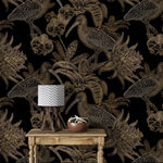 Close-up black and gold wallpaper with line-art birds and orchids behind rustic table with chevron lamp
