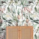 Close-up watercolor tropical jungle wallpaper with monkeys and pineapples behind cane rattan cabinet