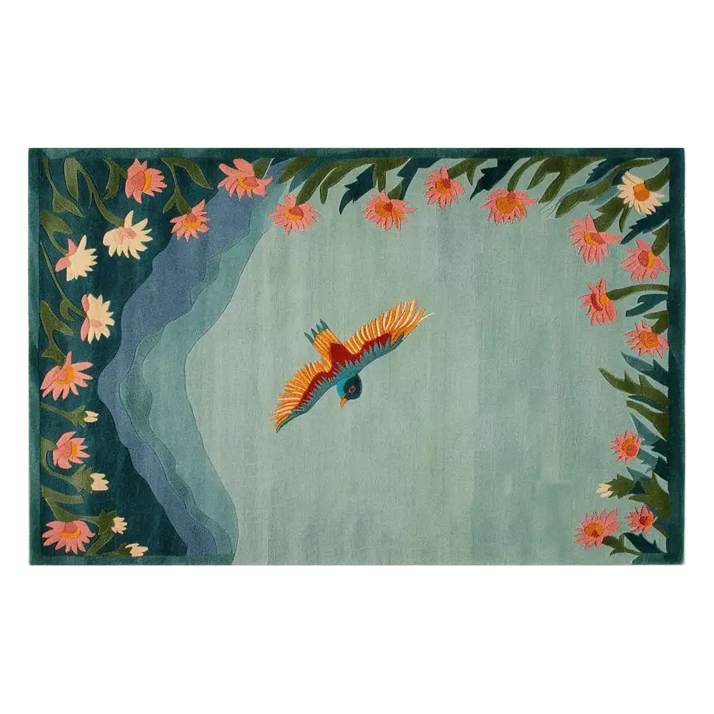 A beautifully crafted area rug featuring a vibrant bird in flight over a serene blue-green background. The edges are adorned with lush floral designs in shades of pink and orange, adding a touch of elegance and nature-inspired charm.