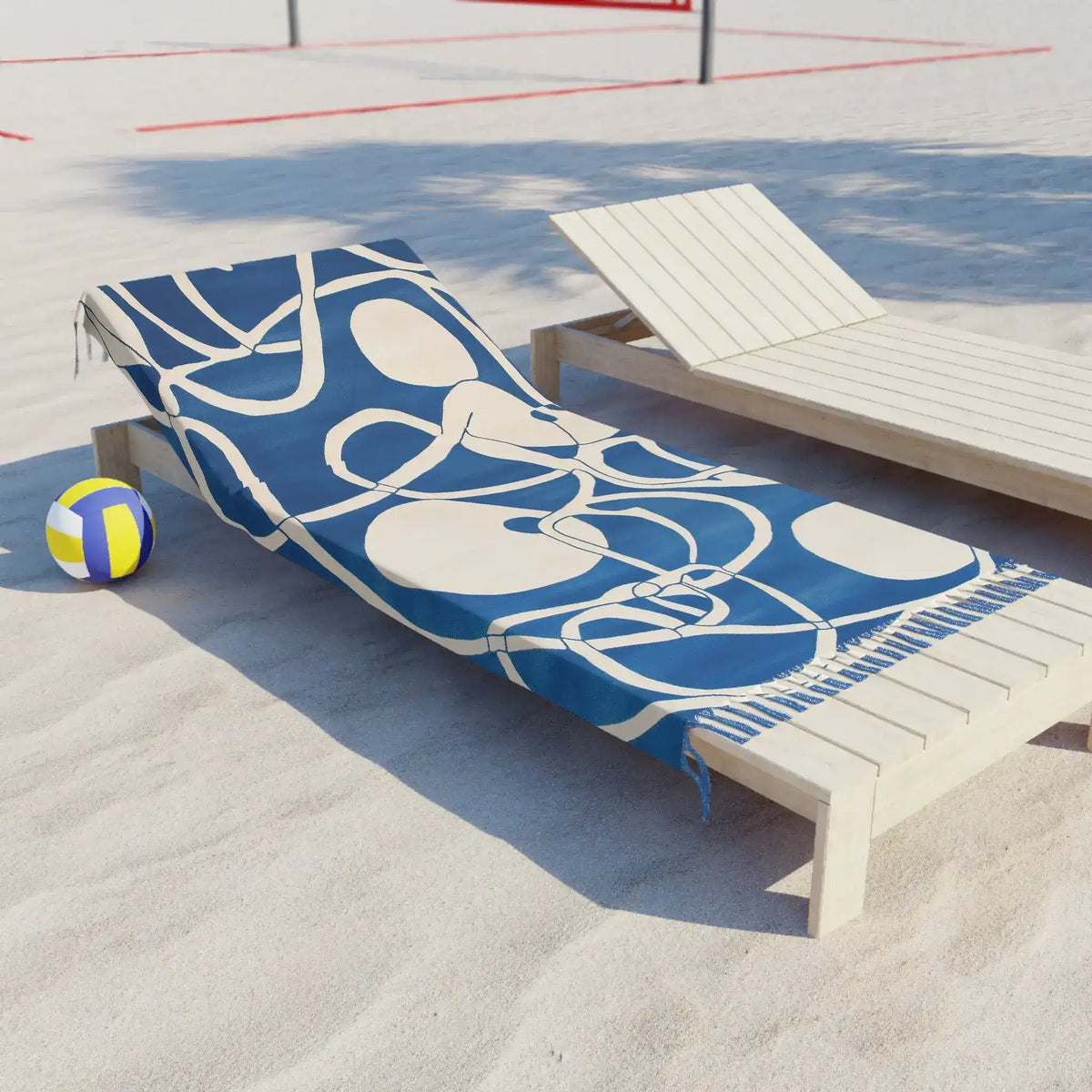 Coastal Waves Abstract Blue and White Beach Towel draped over white lounge chair on sandy beach with volleyball