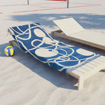 Coastal Waves Abstract Blue and White Beach Towel draped over white lounge chair on sandy beach with volleyball