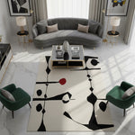 Modern living room with a gray sofa, green chairs, and a black and white abstract rug.
