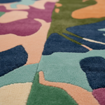 Close-up of a colorful patterned rug with abstract shapes.