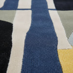 Close-up of a textured fabric with geometric pattern in blue, beige, and black.