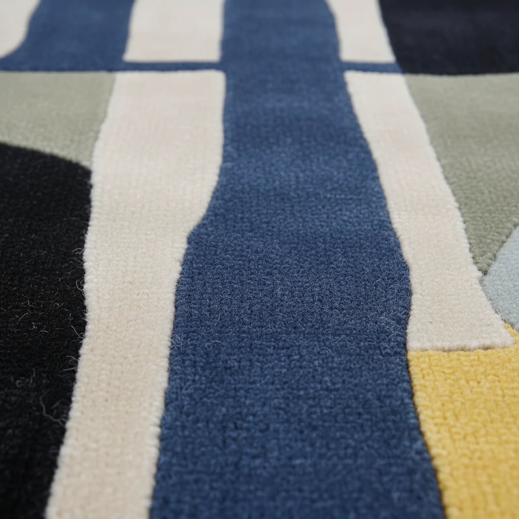 Close-up of a textured fabric with geometric pattern in blue, beige, and black.