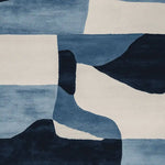 Top view of a contemporary area rug with abstract geometric patterns in shades of blue and white. Ideal for adding a modern touch to living rooms, this wool rug combines style and comfort, making it a perfect choice for living room area rugs.