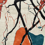 A vibrant area rug featuring an abstract design with bold black lines and splashes of orange and teal, perfect for large living room spaces. This hand-tufted wool rug adds a contemporary flair to any living room area.