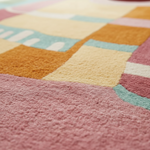 Close-up of a colorful checkered rug with pink, yellow, and blue patterns.