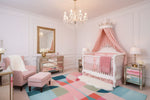 Delicate baby nursery with crib, colorful rug, and decorative elements.