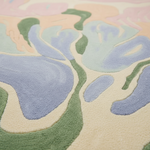 Close-up of a textured rug with abstract patterns in pastel colors.
