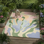 Colorful abstract rug on a wooden deck with plants around