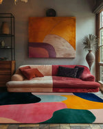 Vibrant and artistic living room featuring a large, colorful chaos hand tufted wool area rug. The abstract design adds a pop of color against the modern sofa and wall art, making it a perfect addition to any living room looking for a unique touch. Ideal for those seeking large area rugs for living room spaces.