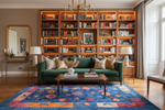 Living room with a green sofa, bookshelves, and a colorful rug.