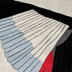 Close-up of the Concrete Currents Hand Tufted Area Rug, showcasing an abstract design in black, white, blue, and red. Perfect for large living room spaces, this contemporary wool rug adds a modern touch to your decor.