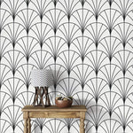 Console with chevron lamp against monochrome round line wallpaper, black-and-white deco fans