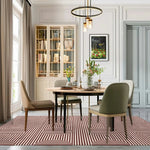 Modern dining room featuring a Contemporary Eclipse Illusion Hand Tufted Wool Rug in red. This large area rug enhances the sophisticated living room, with its striking geometric patterns. Perfect for those seeking stylish area rugs for living room settings.