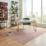 Modern office space with a desk, chair, an abstract wool rug, and bookshelves in a well-lit room.