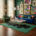 Modern living room with a blue sofa, green armchair, and colorful abstract rug, colorful art on the wall.