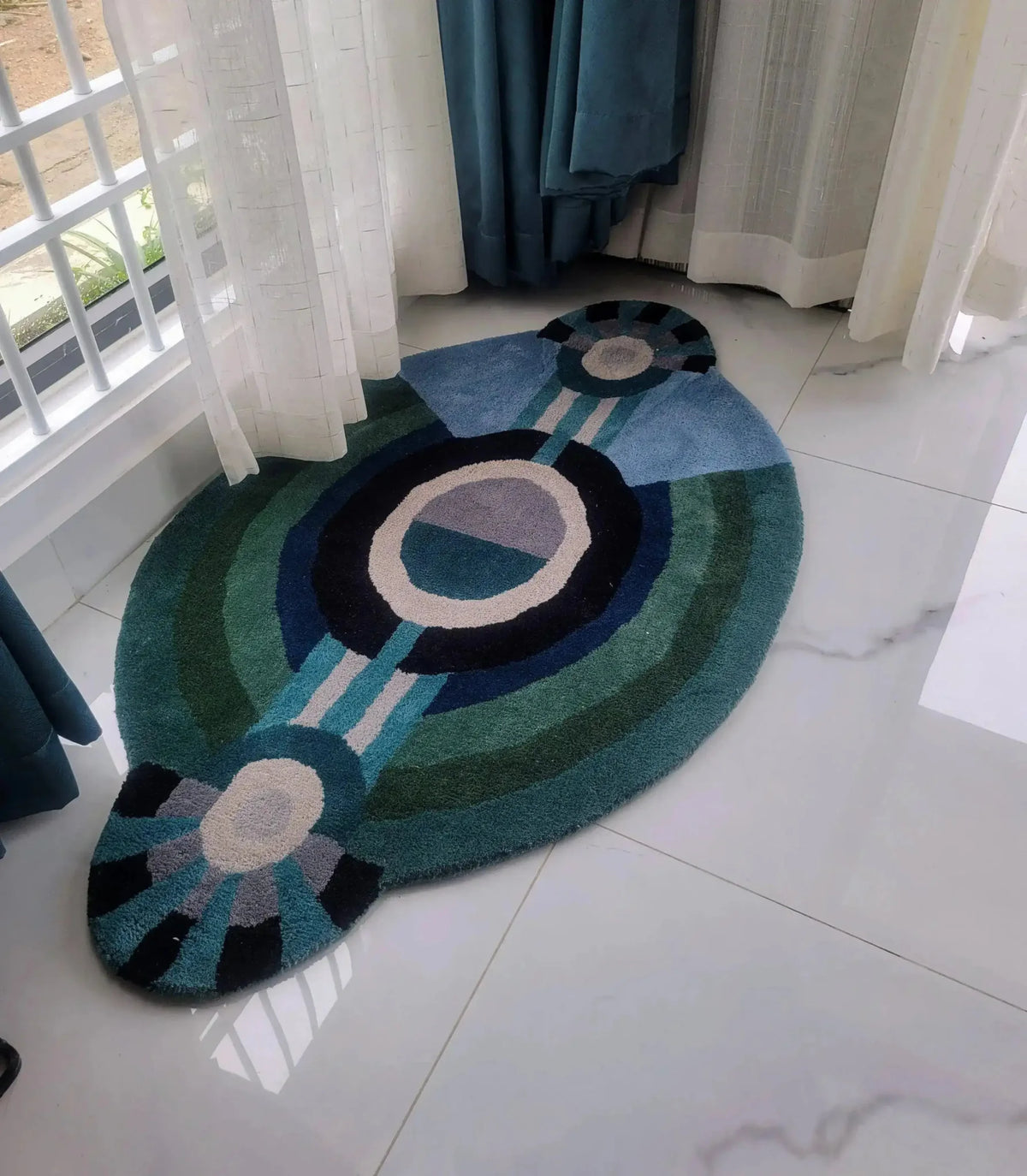 A contemporary round evil eye hand-tufted wool rug in rich shades of blue and green, perfect for adding a modern touch to bedroom décor. This stylish area rug is designed to fit beautifully as a bedroom area rug, offering a cozy and inviting feel. Ideal for those seeking large area rugs with a unique design.