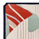 A detailed view of the Contour Line Rhythm Hand Tufted Rug, showcasing an abstract design with bold red, green, and cream colors. This contemporary wool rug is perfect as an area rug for living rooms, especially in an 8x10 size, adding a modern touch to any space.