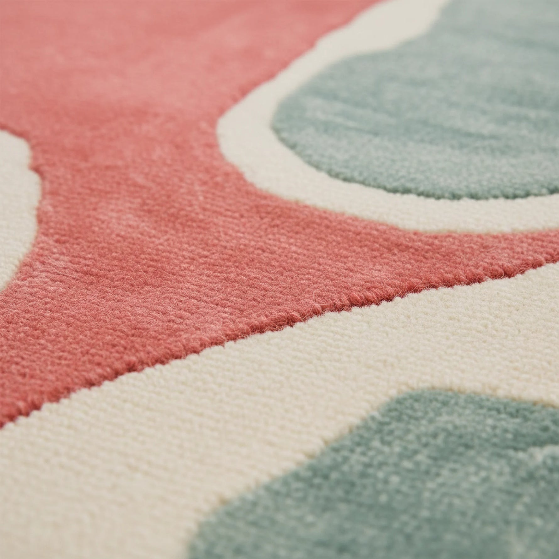 Close-up of a colorful patterned rug with pink, blue, and white shapes.