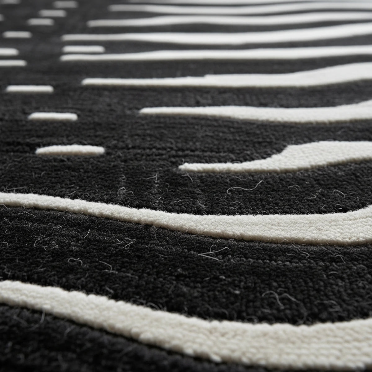 Close-up of a black and white striped rug with a geometric pattern.