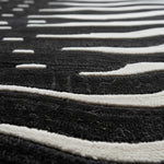 Close-up of a black and white striped rug with a geometric pattern.