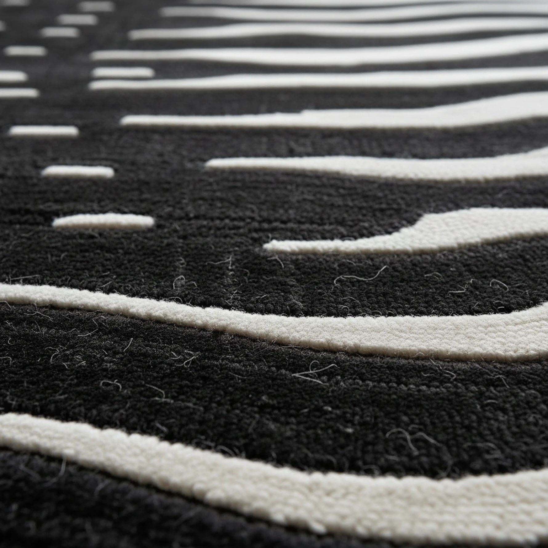 Close-up of a black and white striped rug with a geometric pattern.