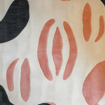 Close-up view of the Coral Whisper Hand Tufted Wool Area Rug showcasing abstract coral and black shapes against a light background. The design is modern and artistic, adding a touch of elegance to any room.