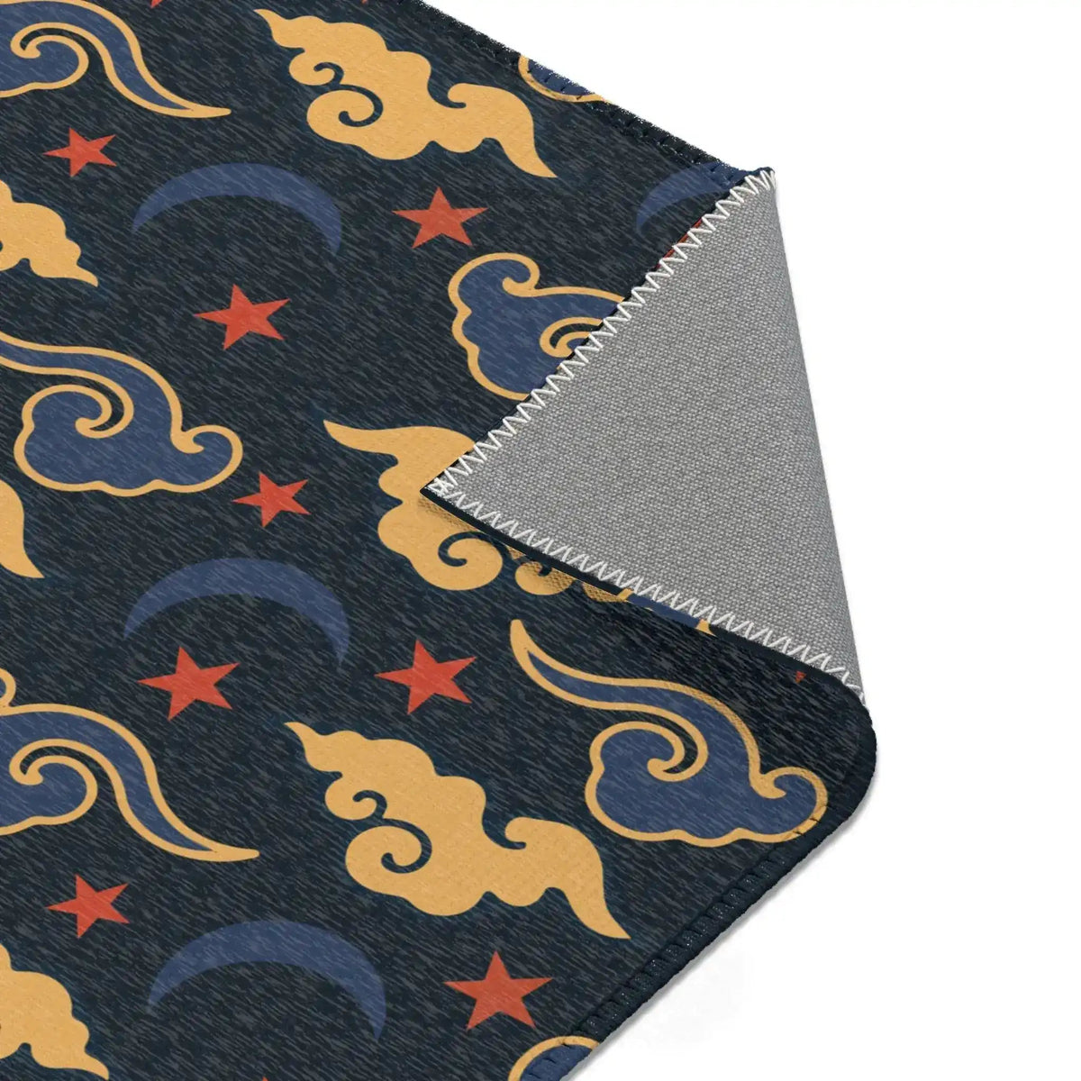 Corner of the Retro Night Sky Accent Rug folded back, gold clouds, red stars on navy with grey backing