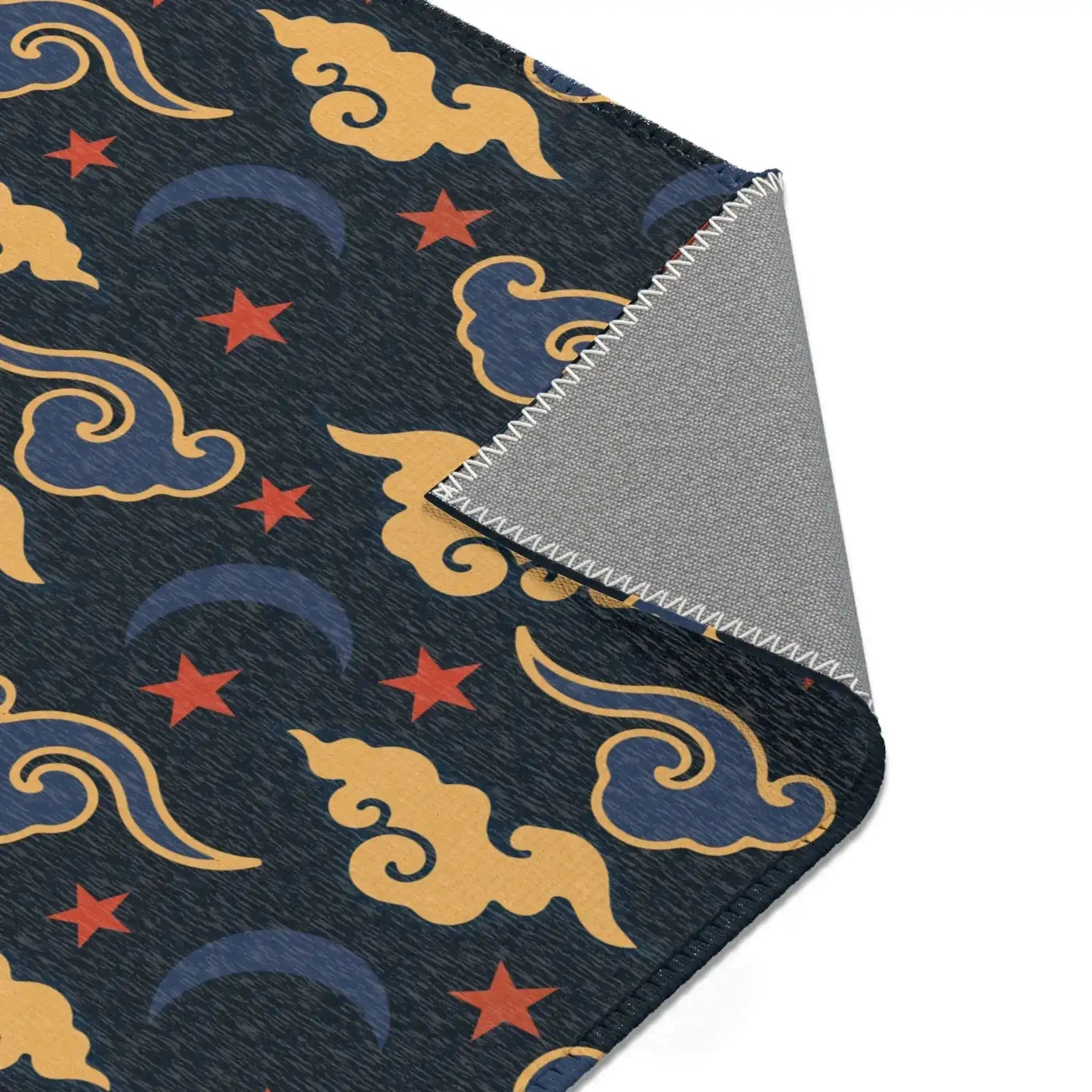 Corner of the Retro Night Sky Accent Rug folded back, gold clouds, red stars on navy with grey backing