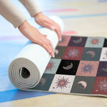 Cosmic Balance mat being rolled on a studio floor, sun and moon tiles with grey underside